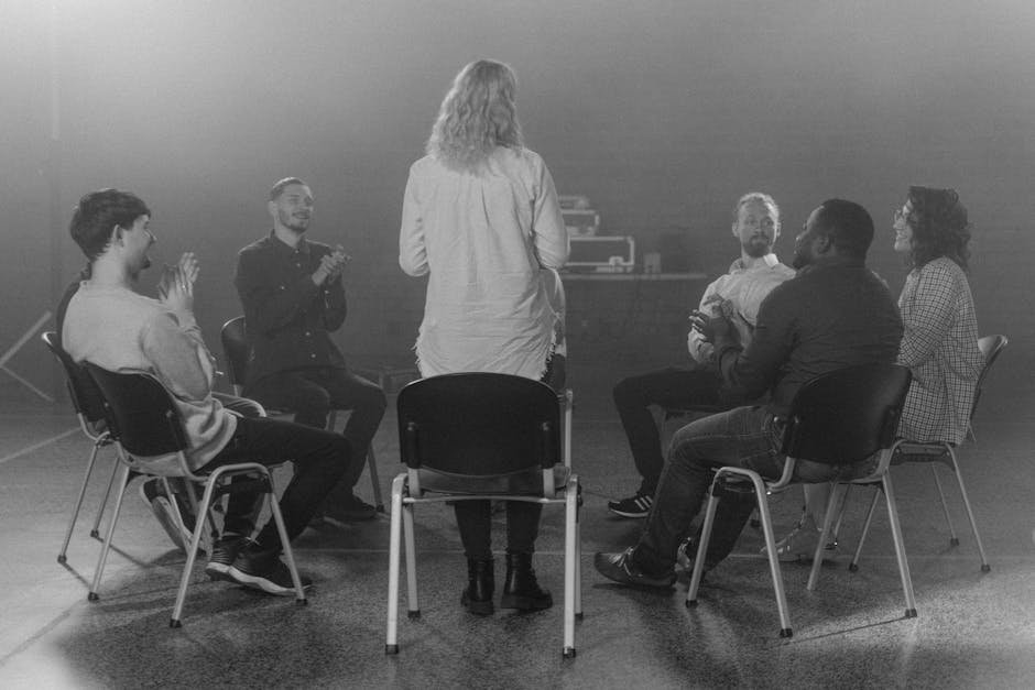 Group therapy session with members in circle in clinic conference room