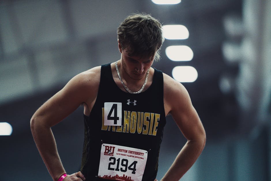 College athlete sitting on track field reflecting after career-ending injury