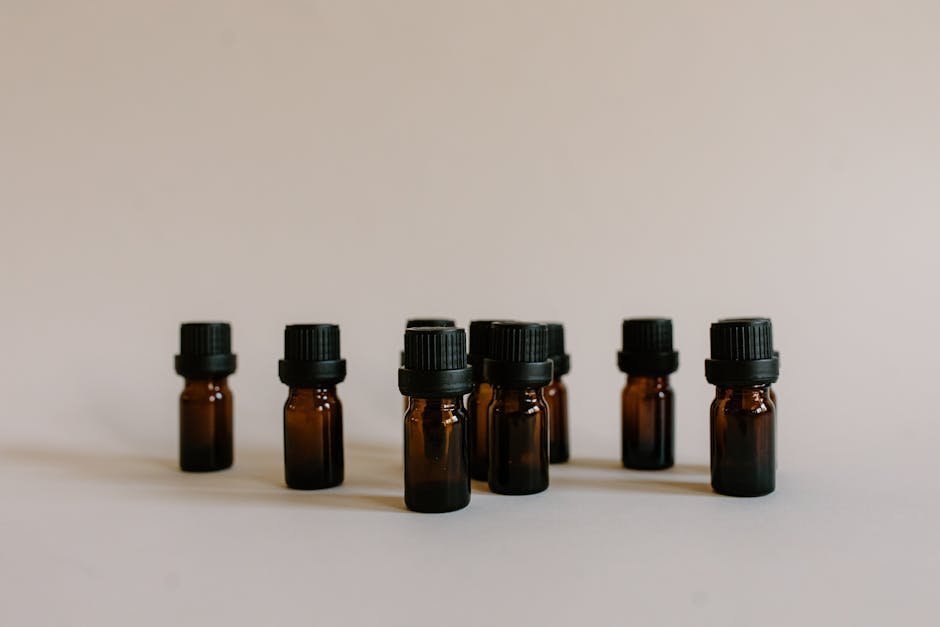 Amber glass bottles of essential oils with dried lavender on a wooden table