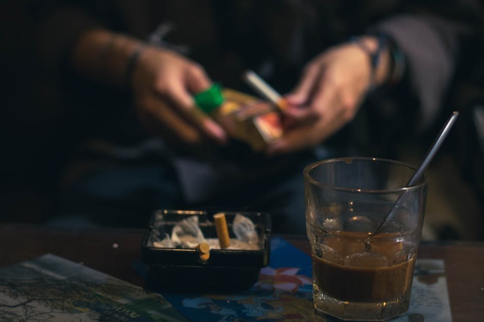Person breaking a cigarette in half with a determined expression