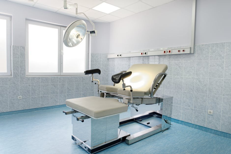 A trauma-informed examination room with soft lighting and a SANE nurse station prepared for a sexual assault forensic exam