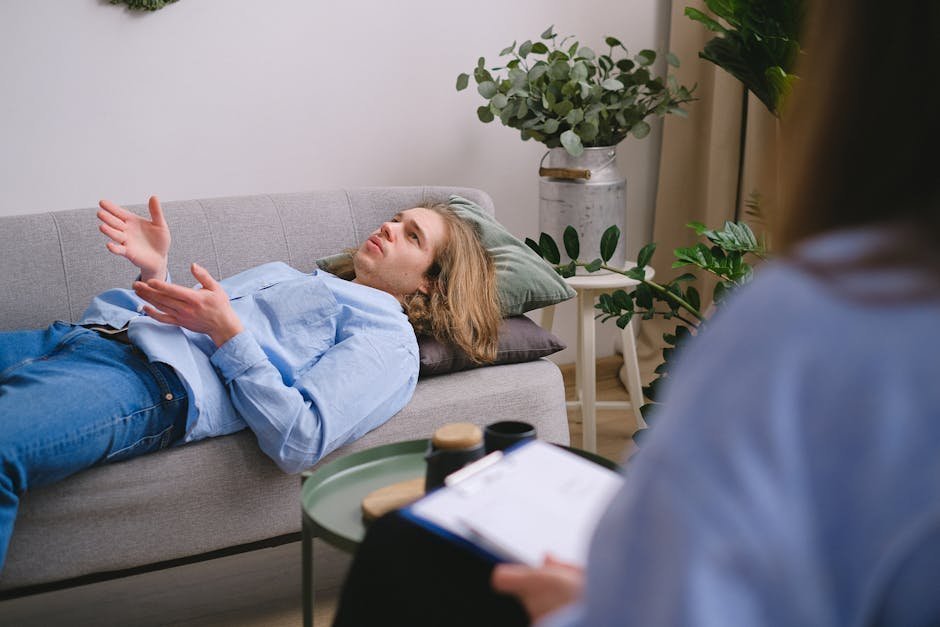 Therapist and client working through a CBT thought record at a desk