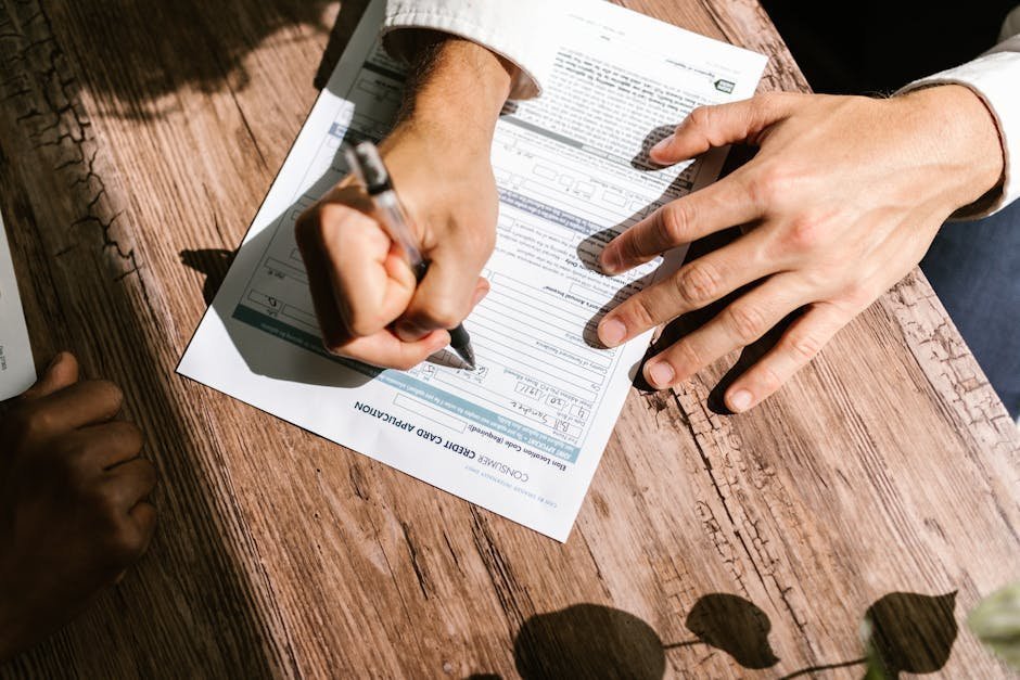 Person reviewing loan documents and rehab cost estimates at a kitchen table