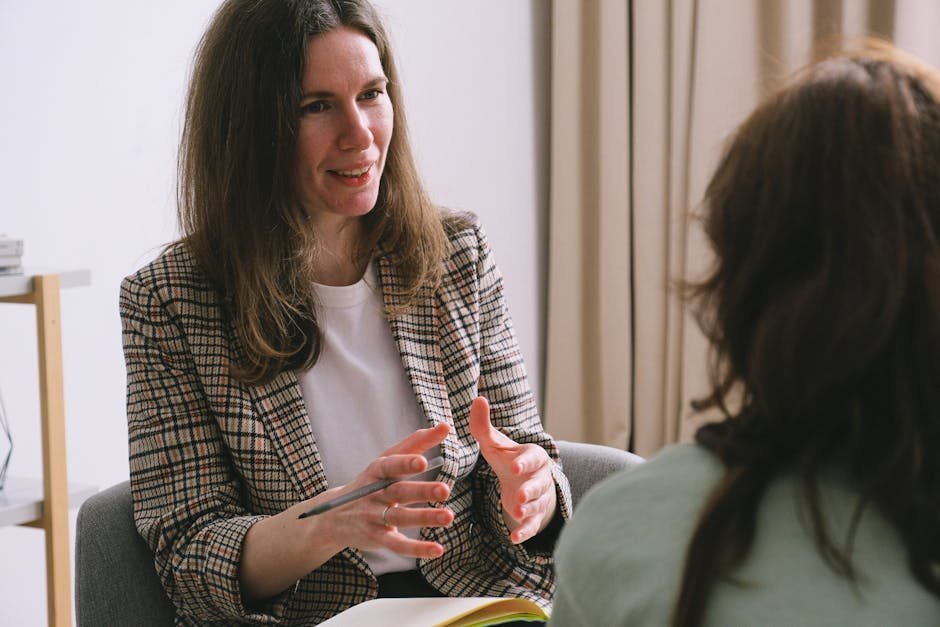 Therapist in quiet office discussing sensory sensitivity framework with thoughtful client