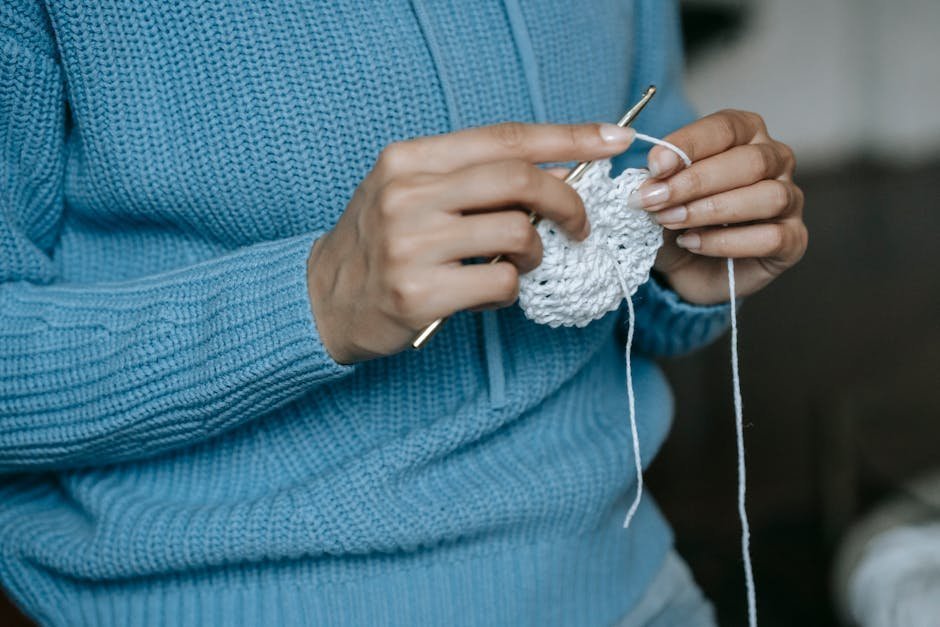 Hands crocheting blue yarn in calm home setting for anxiety relief