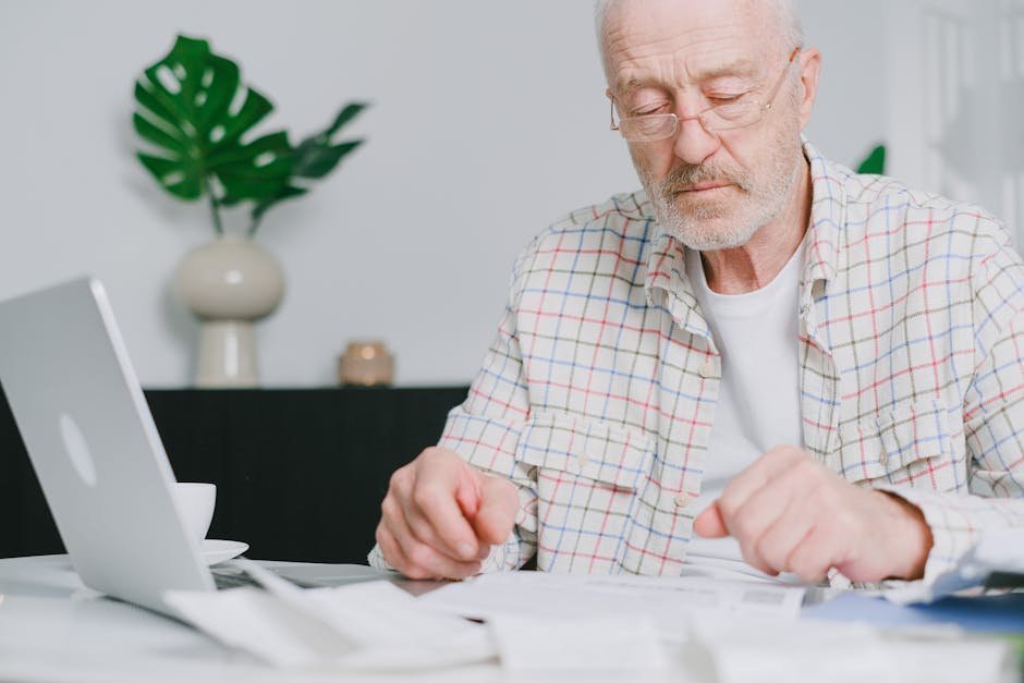 Older man in Louisville home reviewing Humana insurance card and therapist directory at kitchen table