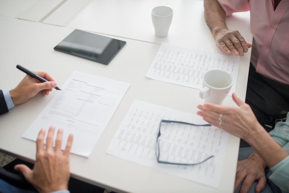 Person at desk reviewing health insurance denial letter with laptop and medical records
